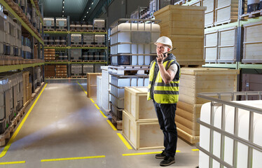 Warehouse logistics supervision involves a worker coordinating storage operations via radio communication among stacked containers, pallets, and crates.