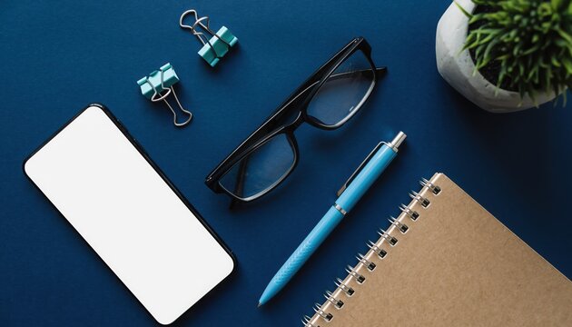 Workspace Essentials: A collection of modern workspace essentials. A simple office setup with notepad, pen, mobile phone, and glasses arranged to inspire creativity and boost productivity.