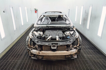 Car body shell completely disassembled after an accident in an auto service garage for major body repair and structural frame restoration work. Industrial shot for advertising and service promotion. © 072Y
