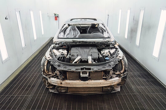 Car body shell completely disassembled after an accident in an auto service garage for major body repair and structural frame restoration work. Industrial shot for advertising and service promotion.