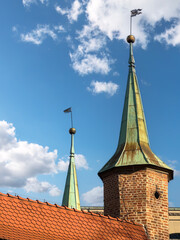 Historic Brick Barbican Turret With Green Copper Spires Reaching Toward a Bright Blue Sky, Krakow, Poland