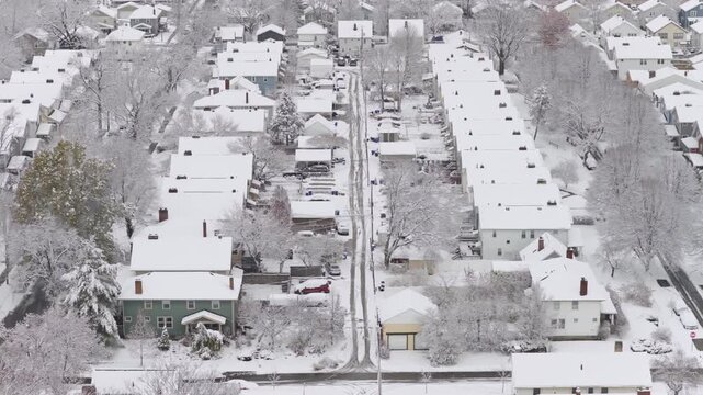 Upper class American suburban suburb near Columbus, Ohio in middle class neighborhood with homes, townhouses, houses, streets, and roads during a wintry and snowy winter storm with cold snow and ice