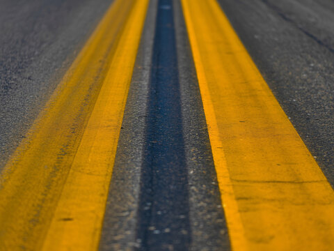 Vibrant yellow road lines lead forward, symbolizing direction, travel, and pathways to new opportunities - Powered by Adobe