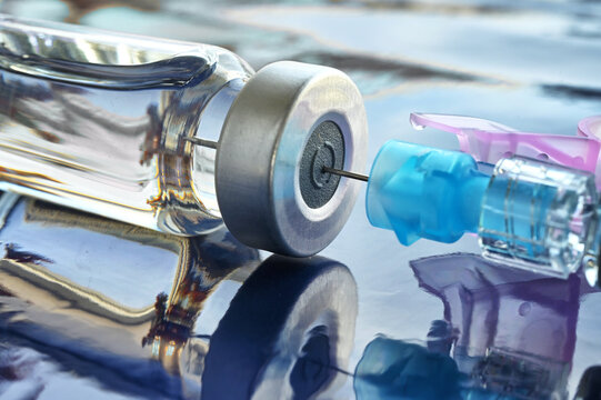 Close up of a syringe in a vaccine booster shot vial for immunization