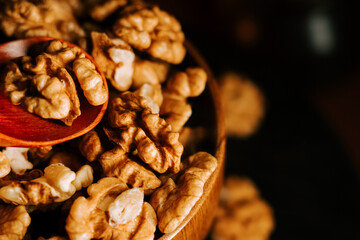Peeled walnuts in a wooden bowl highlight rich textures and earthy tones