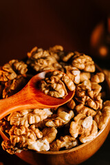 Peeled walnuts in a wooden bowl with a spoon ready for use in a cozy kitchen setting