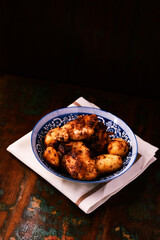 Fried chicken breast with potatoes. Rustic wooden background. Soft focus.	