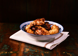 Fried chicken breast with potatoes. Rustic wooden background. Soft focus.	