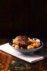 Fried meatballs with potatoes on a rustic background. Selective and soft focus.	