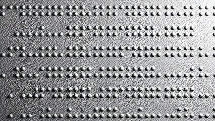 Close up textured background of raised dots forming braille text on a metallic surface