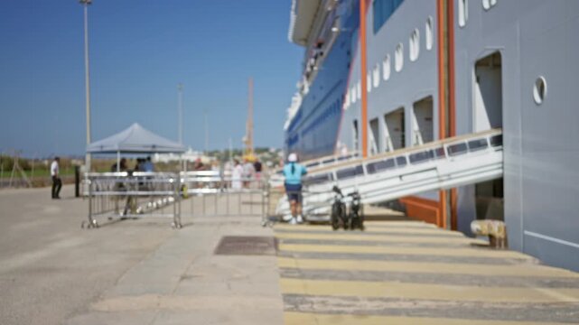 Defocused sunlit cruise ship dockside background outdoor under blue sky; backplate backdrop copyspace template.