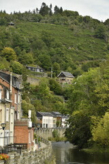 L'Ourthe coulant paisiblement entre les maisons et un bois dans un environnement bucolique à la Roche-en-Ardennes Marche-en-Famenne)