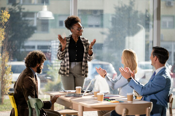 Diverse business team applauding successful presentation in office