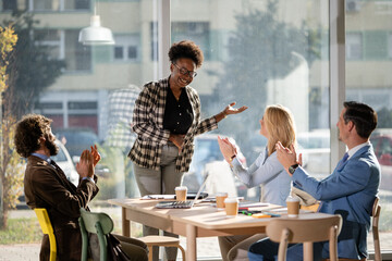 Diverse business team applauding successful presentation in office