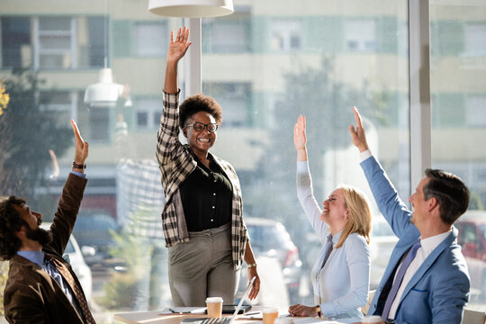 Diverse business team celebrating success raising hands
