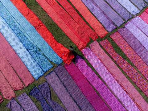Aerial view of vibrant fabrics laid out in neat rows, creating a colorful, textured mosaic under the sun, Narayanganj, Dhaka Division, Bangladesh.