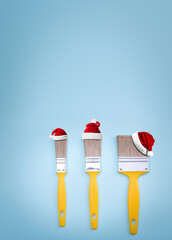 Santa Claus Hat on brushes for painting on blue colored paper texture. Christmas and New Year celebration