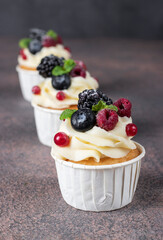 Homemade cupcakes decorated with cream cheese and berries