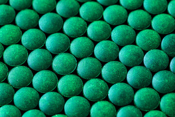 Aquarium fish fodder closeup.Pile  granules spirulina for feeding tropical aquarium fish,Top view.Dark Green round tablets of organic spirulina.Aquarium