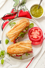 Baguette sandwich with pesto, prosciutto, tomato, burrata and arugula.selective focus