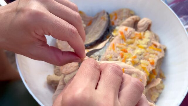 Woman's hands carefully removing bones from fish