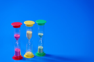 Hourglasses on blue background with copy space
