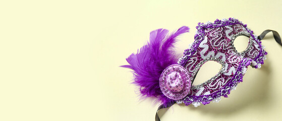 Beautiful purple carnival mask with feathers on beige background