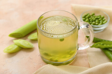Glass cup of tasty vegetable broth on beige background
