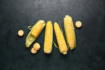 Fresh corn cobs on black background