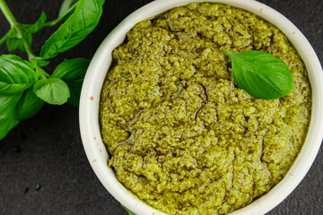 Pesto sauce basil, olive oil, parmesan, pine nuts, garlic natural product tasty snack fresh delicious gourmet food background on the table rustic top view copy space