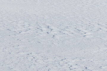 An empty groung covered with clear white snow, background texture