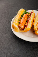 Hotdog fried onions, sausage, bun, sauce fast food tasty snack fresh delicious gourmet food background on the table rustic top view copy space