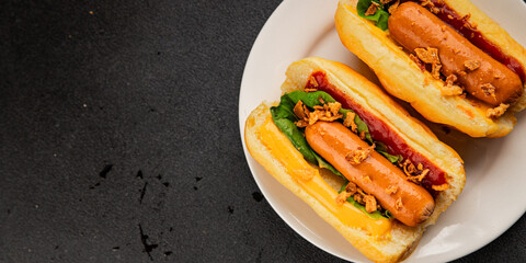 Hotdog fried onions, sausage, bun, sauce fast food tasty snack fresh delicious gourmet food background on the table rustic top view copy space