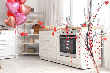 Tree branches with paper hearts garland in festive kitchen. Valentine's Day celebration