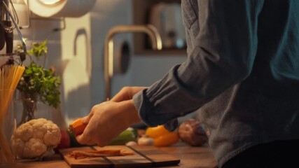 A person skillfully peels raw carrots in a warm kitchen. Fresh vegetables surround them, and the scene conveys a relaxed cooking atmosphere, perfect for meal preparation - Powered by Adobe