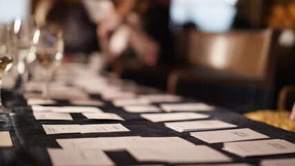 Medium shot of professionals arranging name tags and materials at a banquet networking event preparing to welcome attendees in a formal setting.