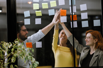 Collaborative brainstorming session in a modern office with colorful sticky notes on the wall