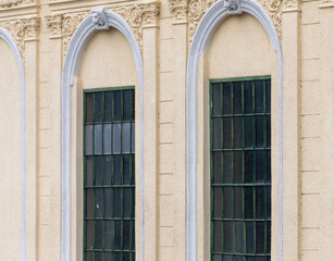 Facade of a classical building with arched windows and decorative stucco in a historical architectural style