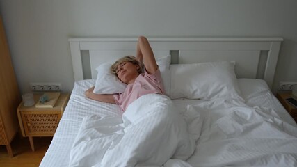 Frustrated middle aged woman waking up in bed feeling unwell after bad dream on uncomfortable pillow, trying to catch on sleep. Stressed female suffering from insomnia and lack of rest during night.