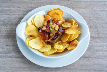 Delicious bife a portuguesa served with crispy potato chips in a stylish dish, showcasing vibrant colors and appetizing presentation