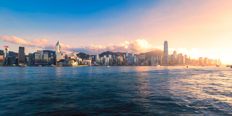 Scenic, awesome view of Victoria Harbour and Hong Kong's fantastic skyline, with its impressive skyscrapers, against a dramatic sunset and sky