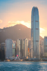 Scenic, awesome view of Victoria Peak and Hong Kong's fantastic skyline, with its impressive skyscrapers, against a dramatic sunset and sky