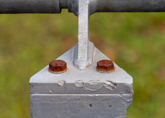 Two bolts with heavy corrosion on a metal corner element of the structure