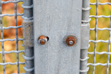 Rusty and metal bolts on galvanized fence structure as technical industrial texture for design