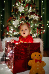 Little girl sitting in a gift box at Christmas day