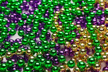 Colorful beads for Mardi Gras celebration as background, closeup