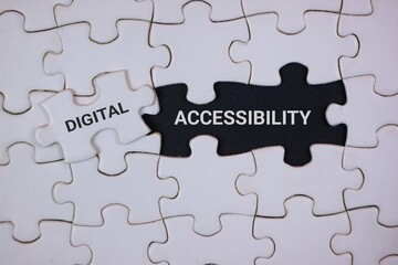Fototapeta premium A close-up of interlocking puzzle pieces highlighting digital accessibility. The black piece labeled ACCESSIBILITY and a white piece labeled DIGITAL, symbolizing inclusive technology and design.