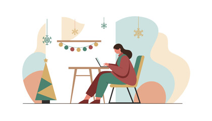Woman working on laptop at desk in a cozy home office decorated for Christmas and winter holidays