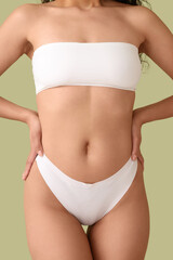 Fototapeta premium Beautiful young African-American woman with stretch marks on her body against green background, closeup