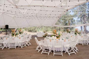 Coziness and style. Modern event design. Table setting at wedding reception. Floral compositions...